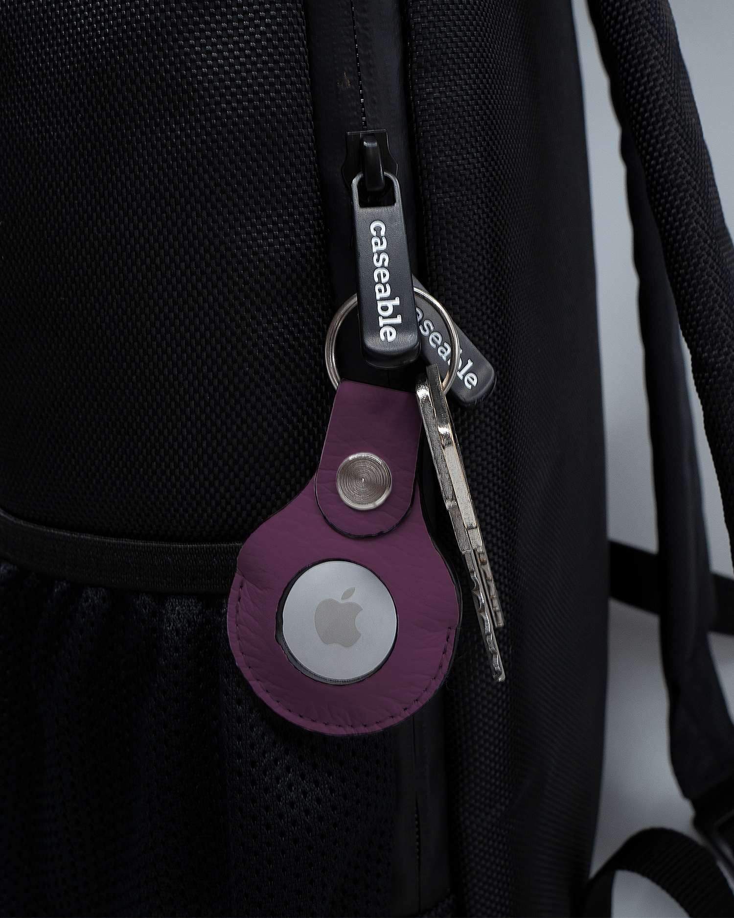 AirTag Holder with design PLUM attached to a bag