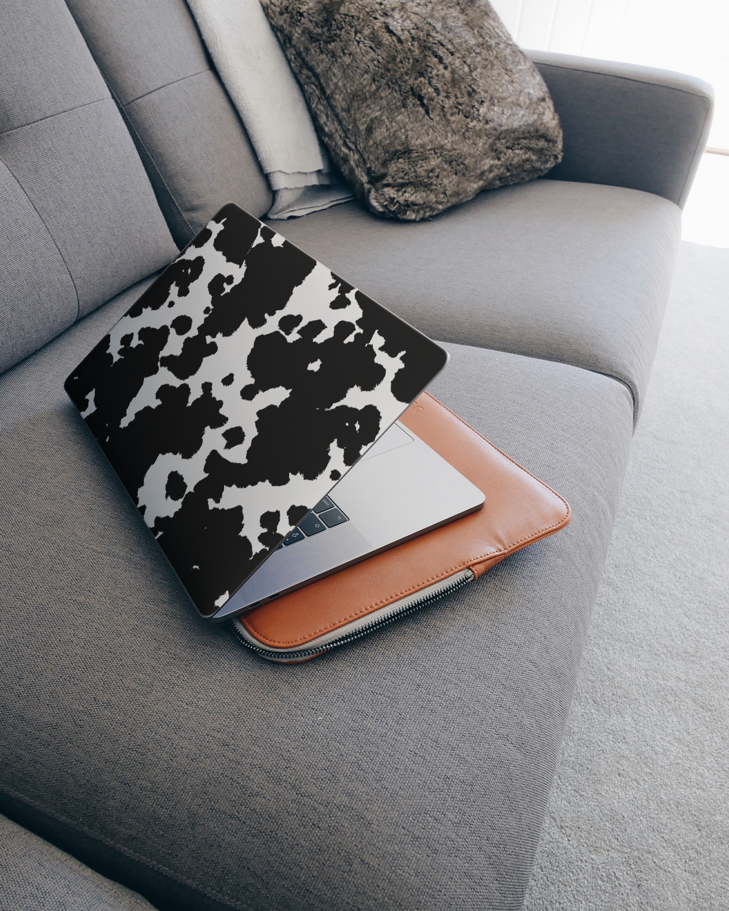 Cow Print Laptop Skin for 15 inch Apple MacBooks on a couch
